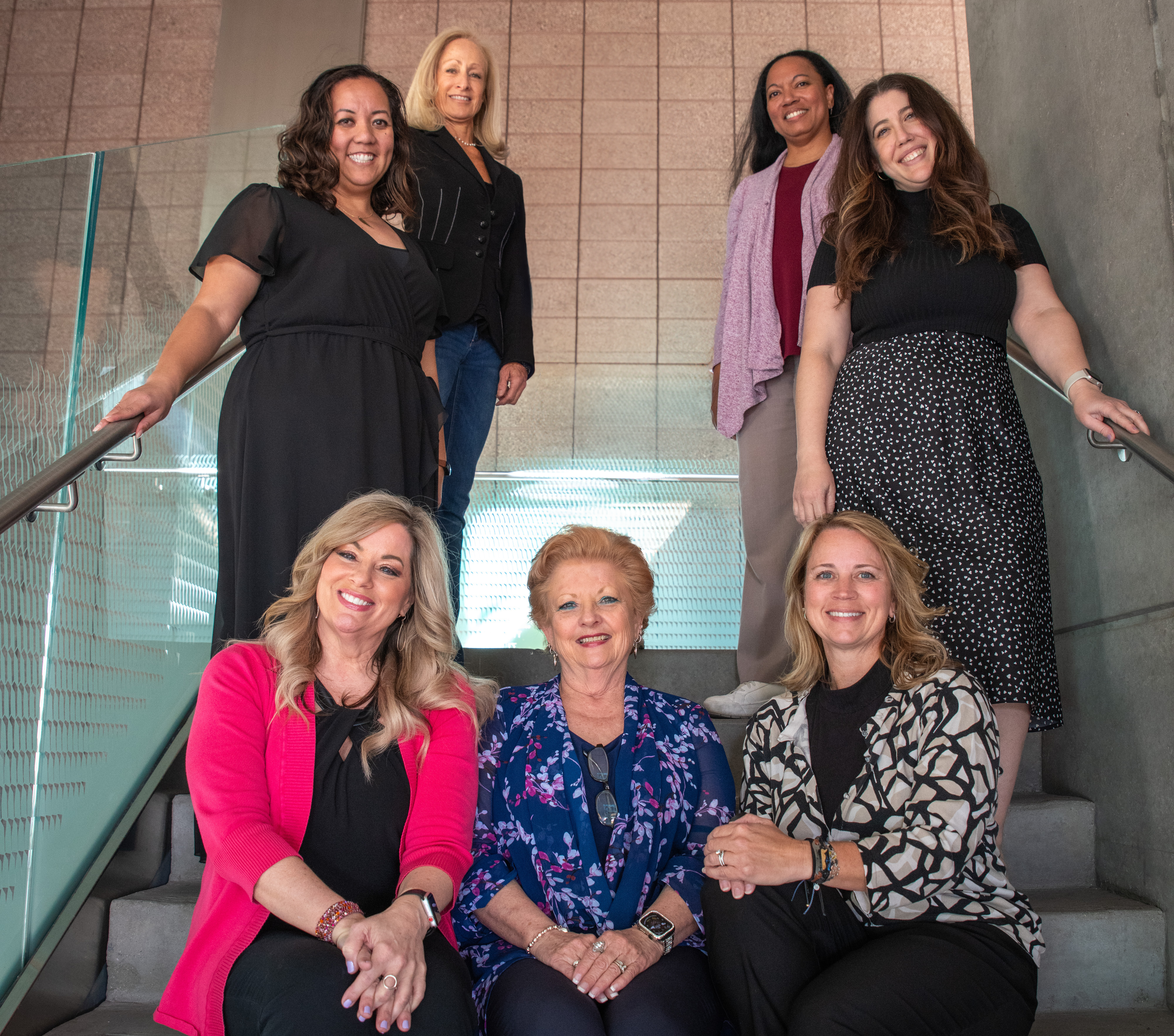 The 2024 3TC working group smiles and sits together in a stairwell.