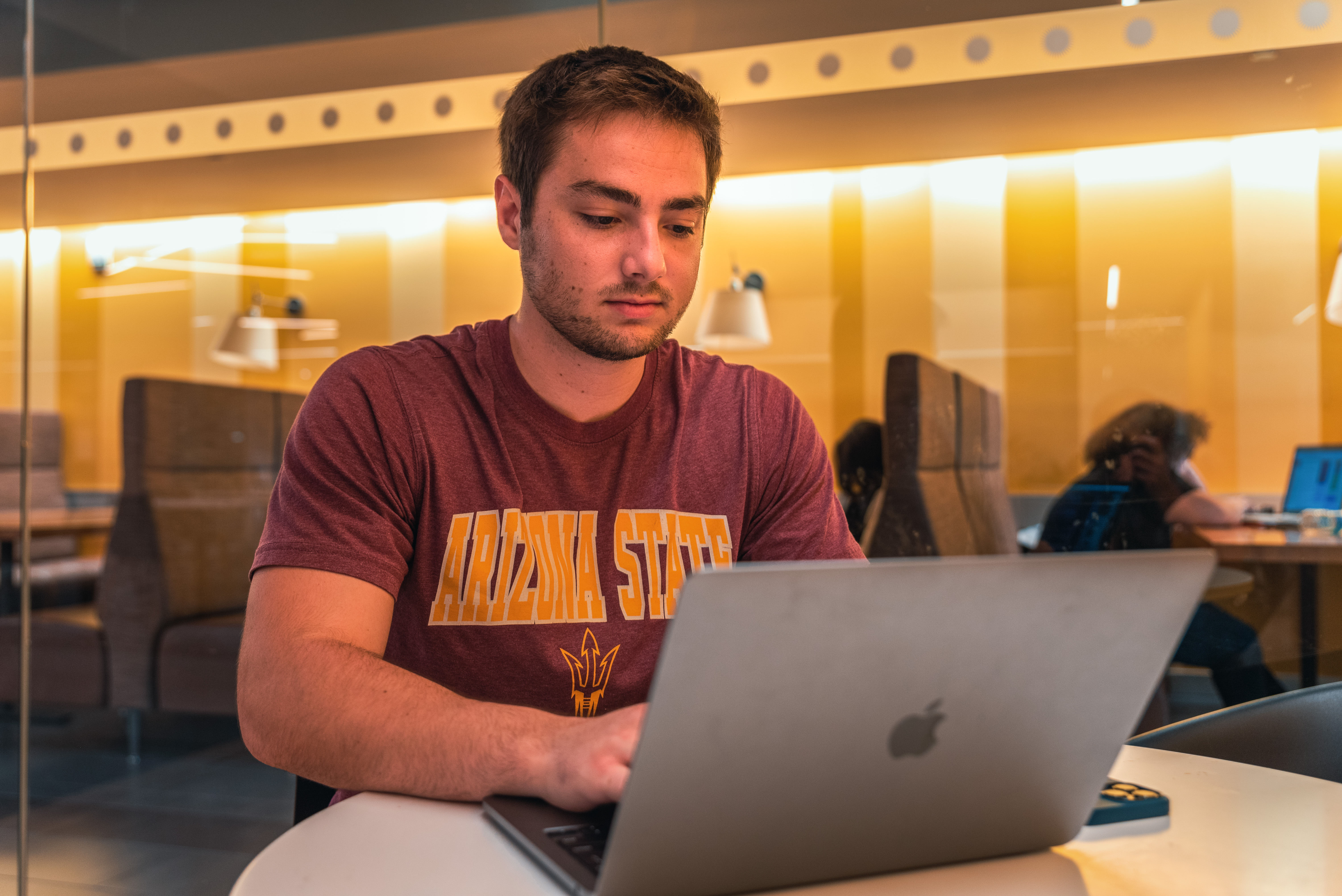 A student works on a laptop in a library