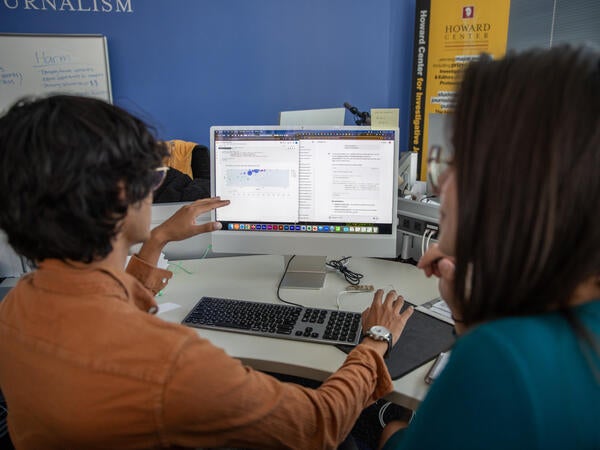 Two students facing a computer screen