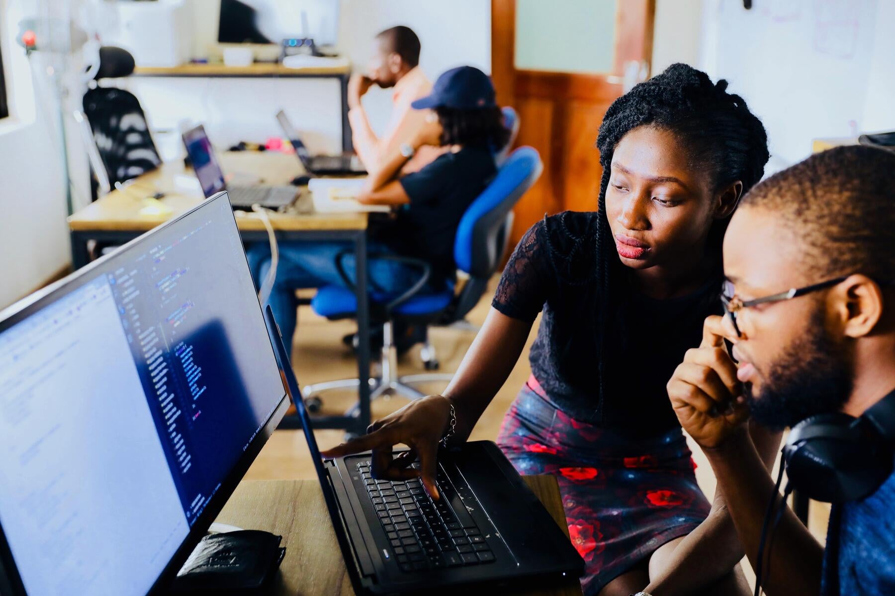 Two people are working at a computer. 