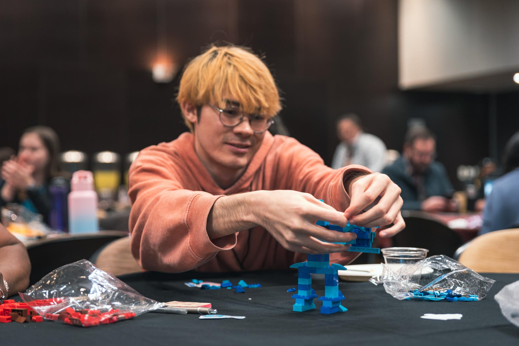 Person sitting at table building legos