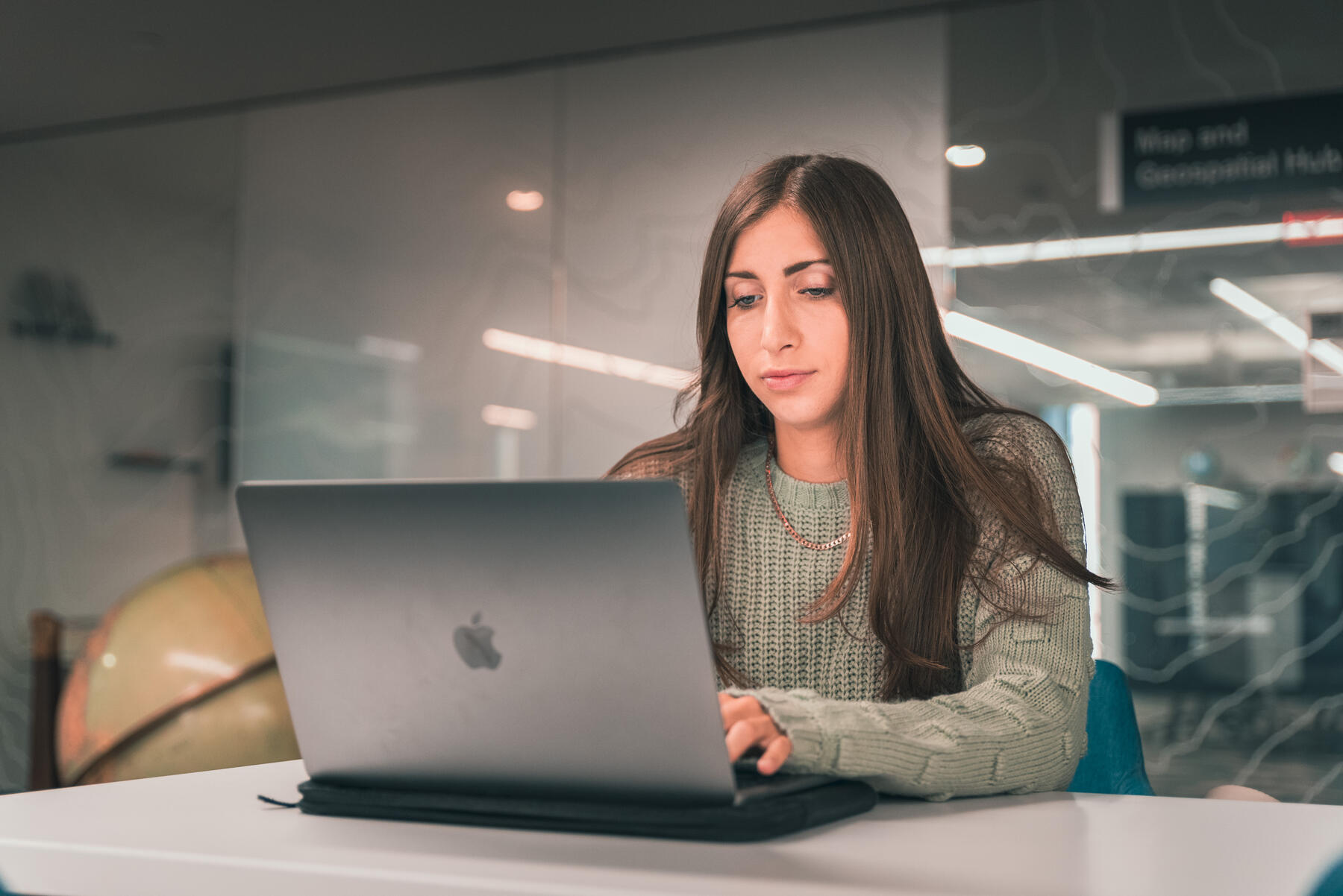 Student sitting at desk working on laptop. 