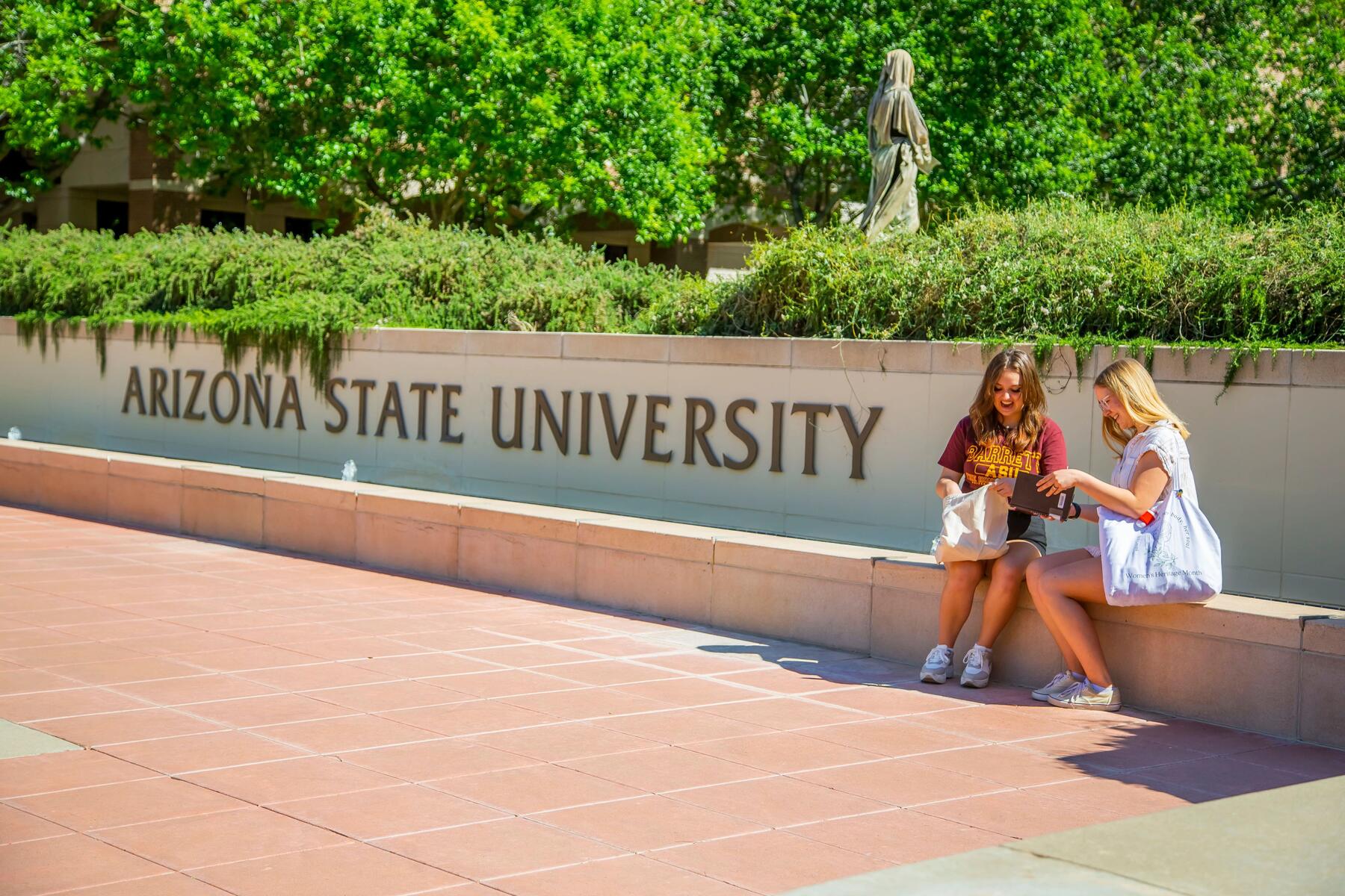 Students sitting on bench on ASU Campus