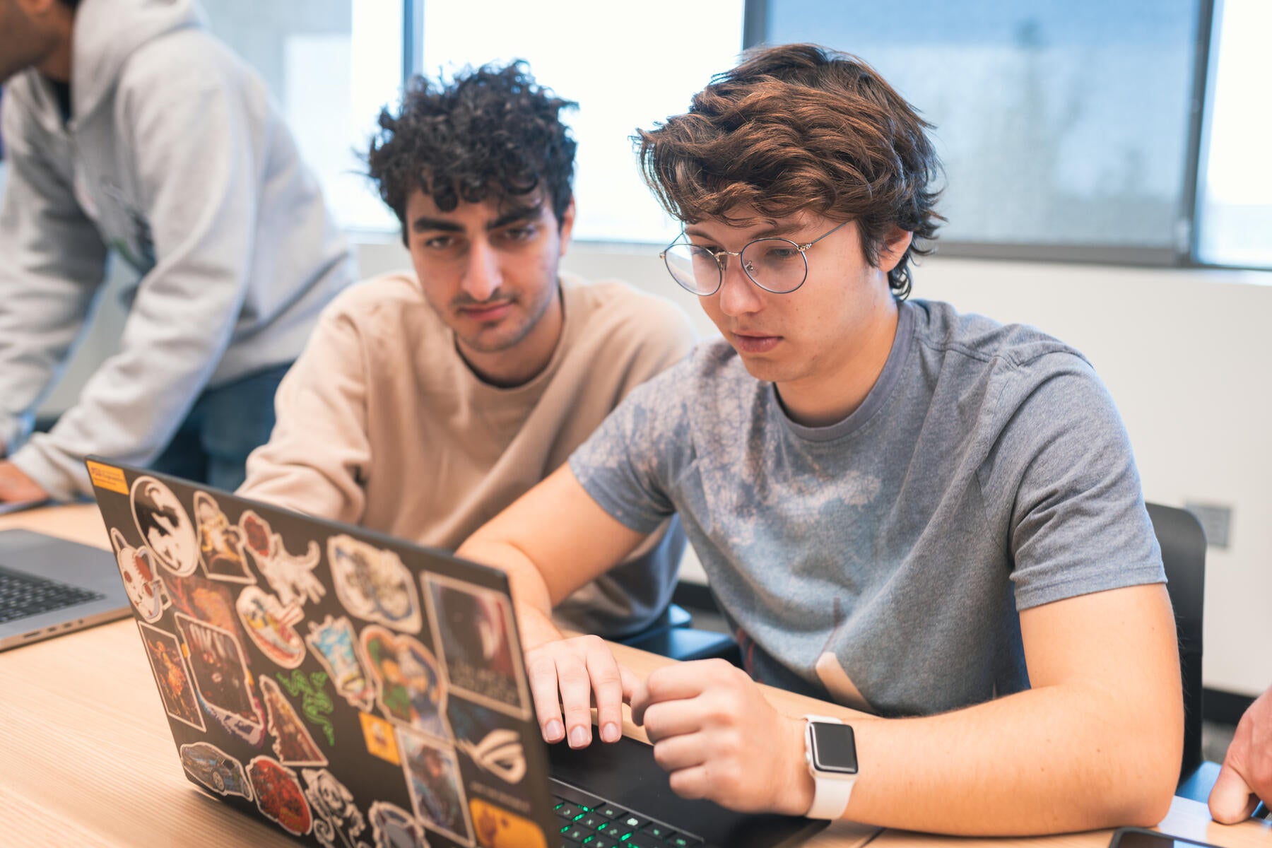 Two students working at their laptops