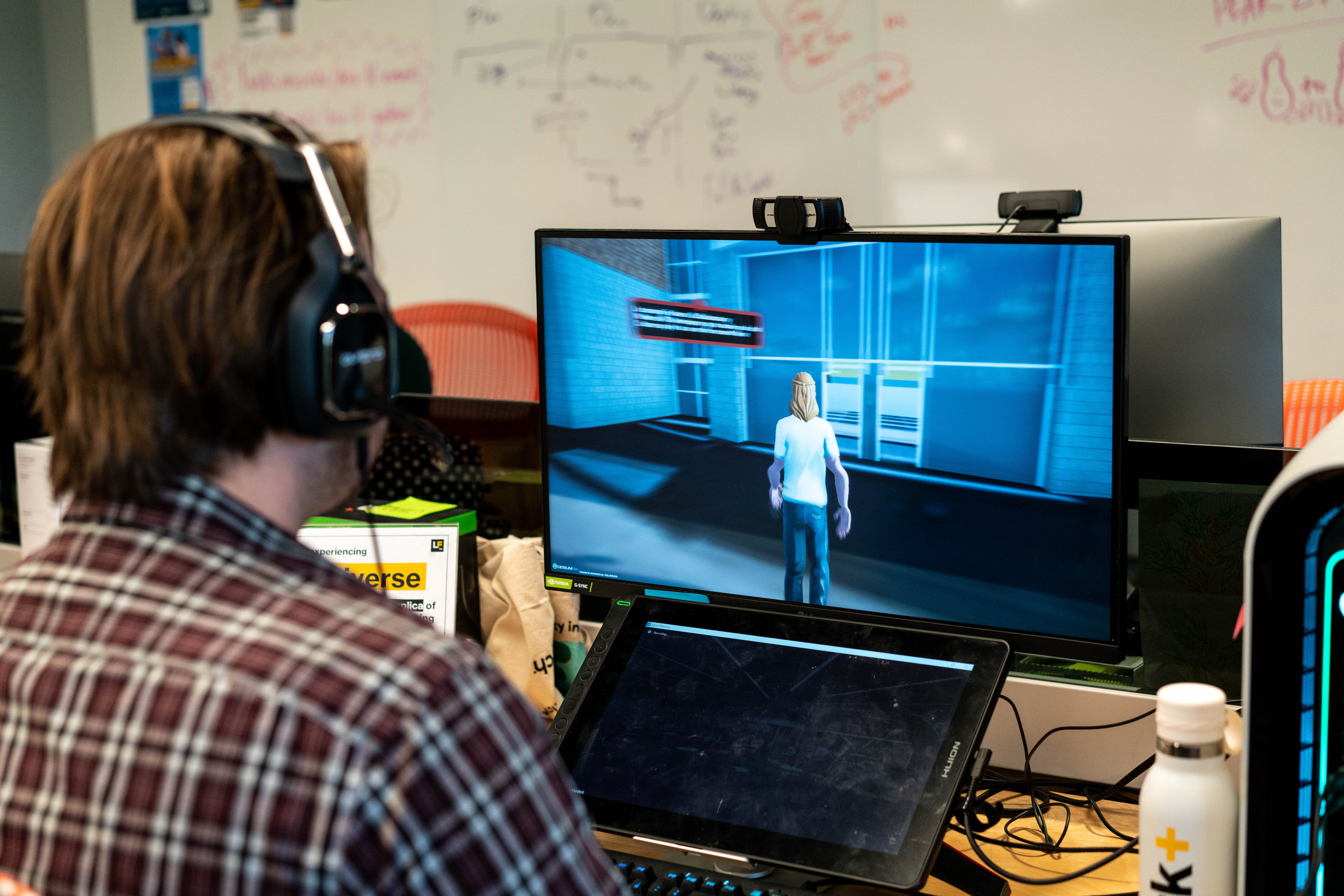 Student on computer at desk with screen showing the digital twin and avatar 