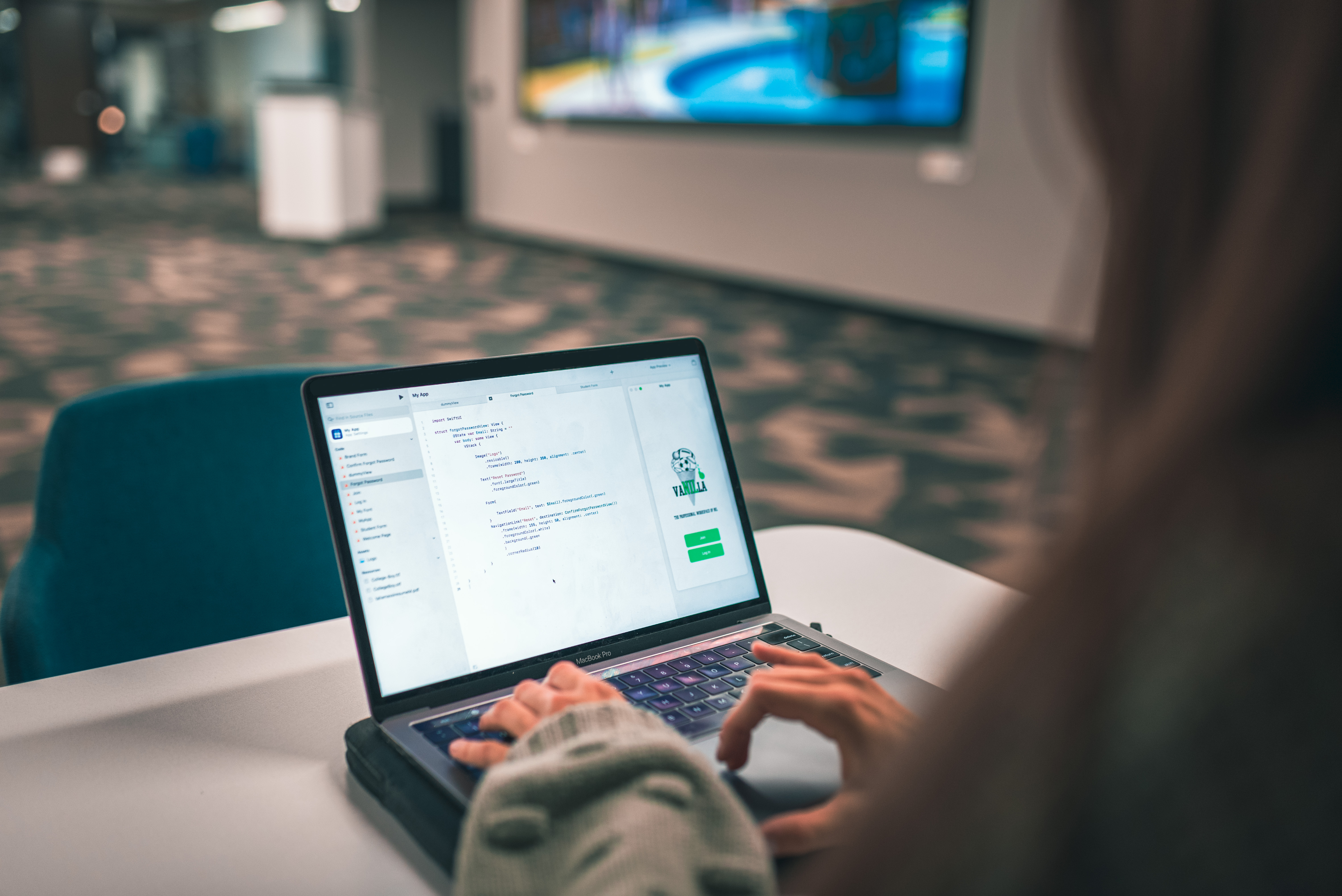 Student at desk with laptop screen primarily shown. 