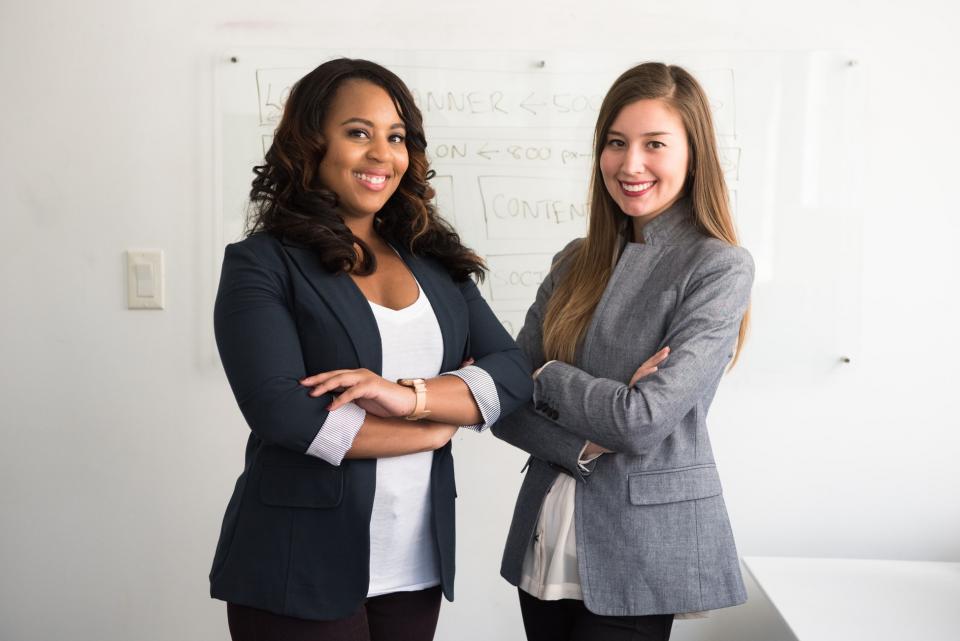 Two women standing next to each other posing