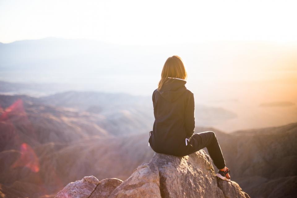 Women sitting on a rock looking at the horizon