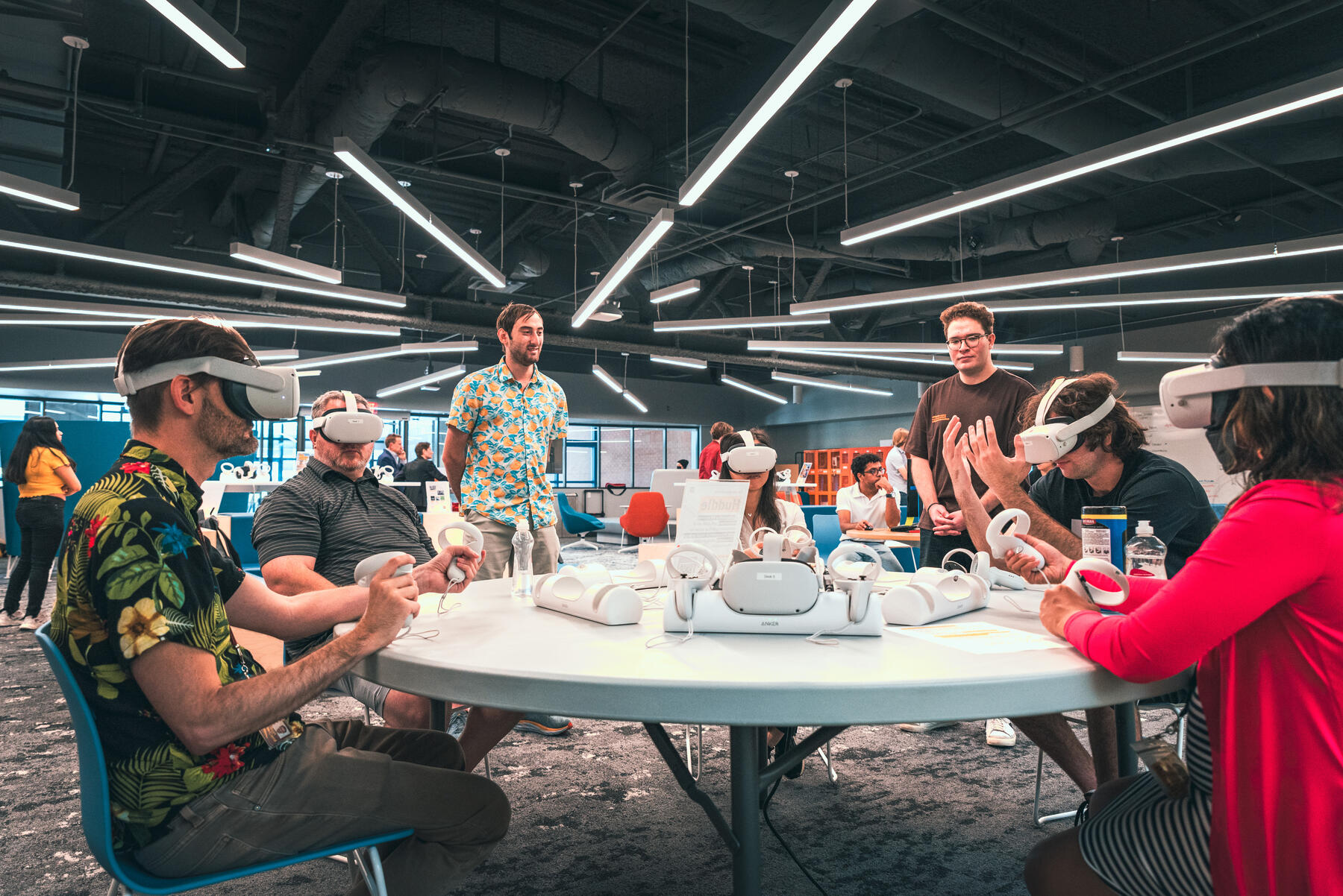 People sitting at round table with virtual reality headset on